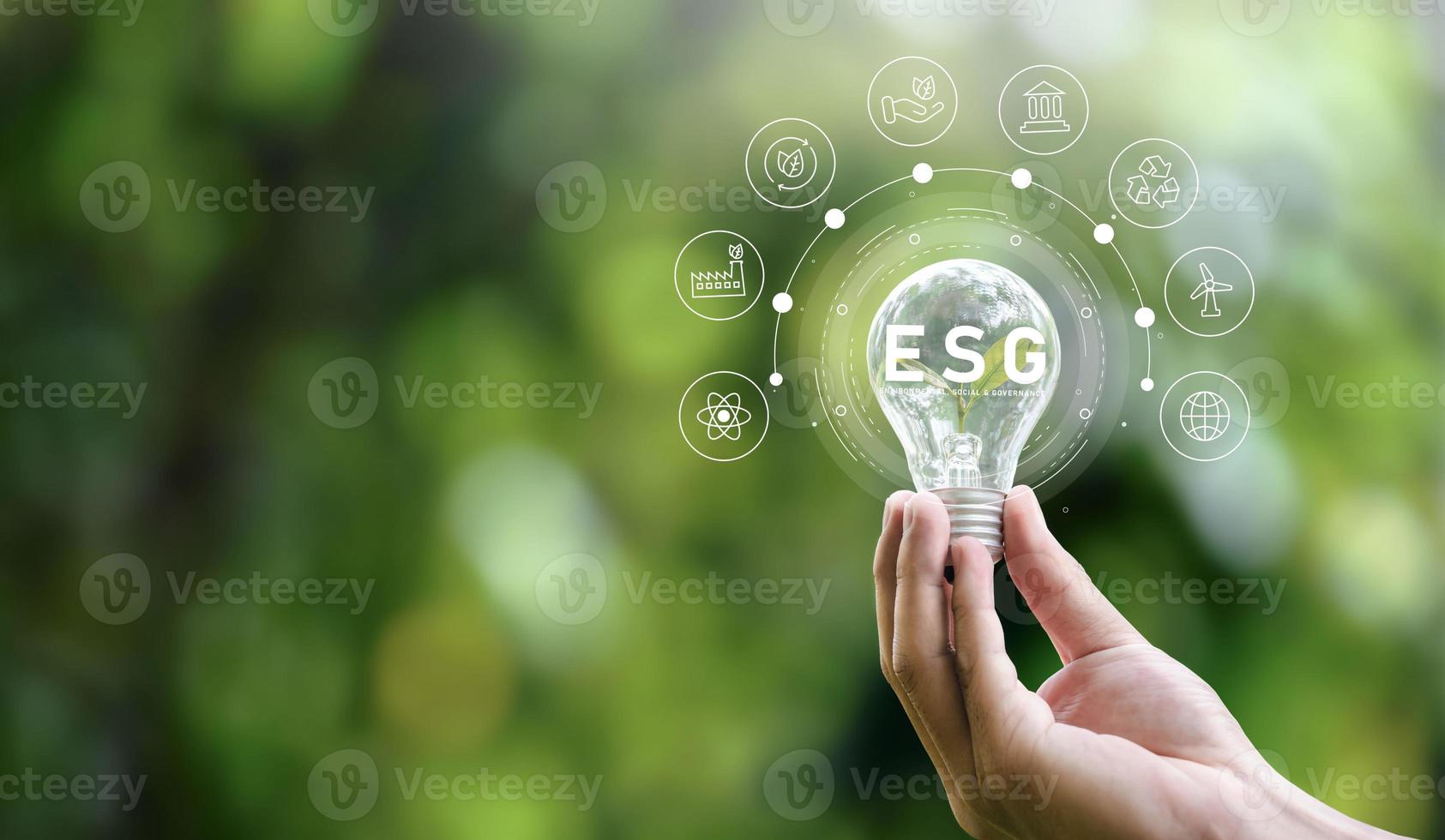 conceito de ícone esg na mão segurando lâmpada para ambiental, social e governança em negócios sustentáveis e éticos em conexões em rede sobre fundo verde. foto