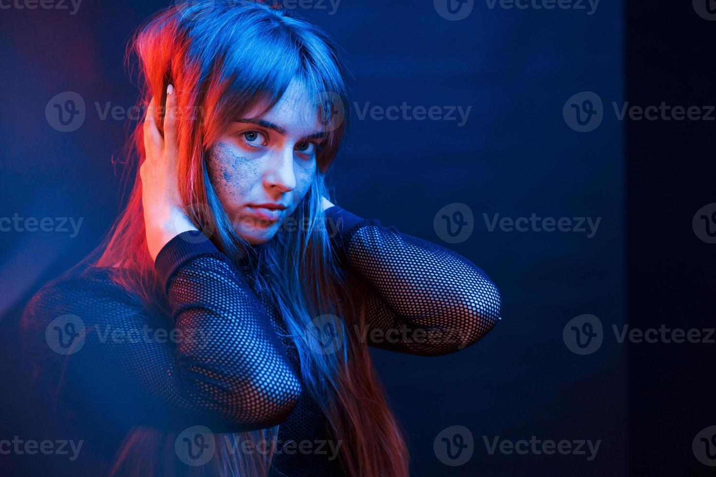 tocando cabelo bonito. studio filmado em estúdio escuro com luz neon. retrato de jovem foto