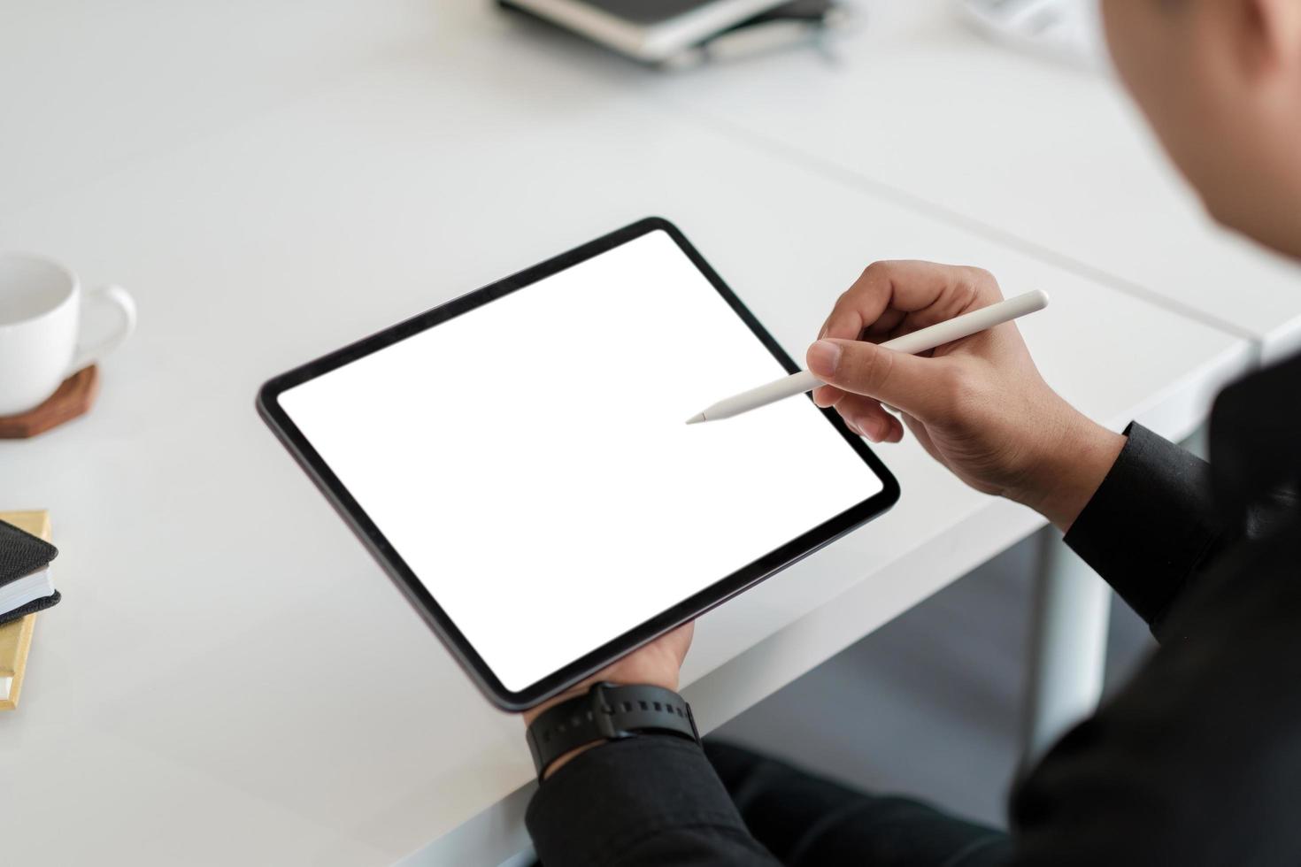 macho asiático desenhando em um tablet de computador de tela em branco branco com caneta stylus foto