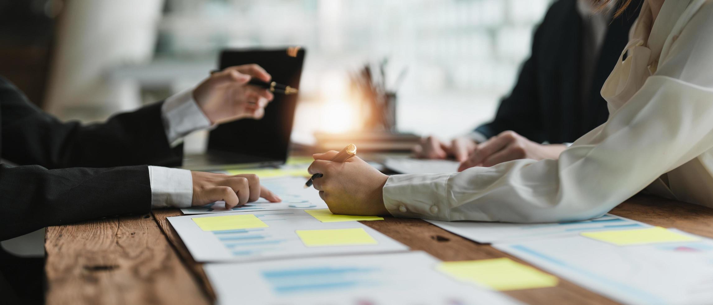 pessoas de negócios reunidas usando computador portátil, calculadora, notebook, papel gráfico do mercado de ações para planos de análise para melhorar a qualidade no próximo mês. conceito corporativo de discussão de conferência foto