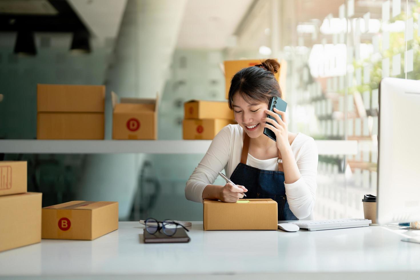 empreendedor de pequenas empresas de inicialização sme de mulher asiática freelance usando um laptop com caixa de embalagem de marketing on-line de sucesso alegre caixa e conceito de ideia de sme de entrega. foto