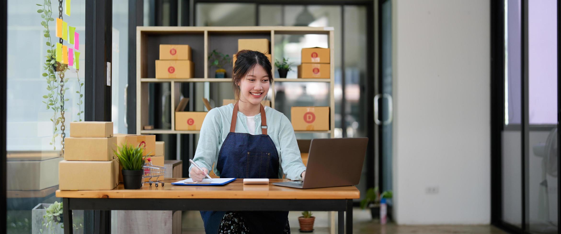 startup pequena empresa sme, empresário proprietário usando smartphone ou tablet recebendo e verificando o pedido de compra de compra on-line para preparar a caixa do produto do pacote. vendendo conceito de ideias online foto