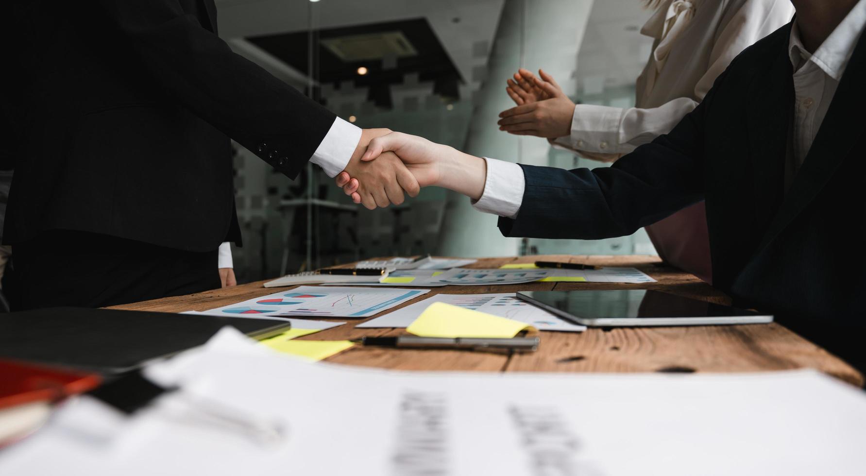 empresários apertando as mãos, terminando a reunião, etiqueta empresarial, parabéns, conceito de fusão e aquisição foto