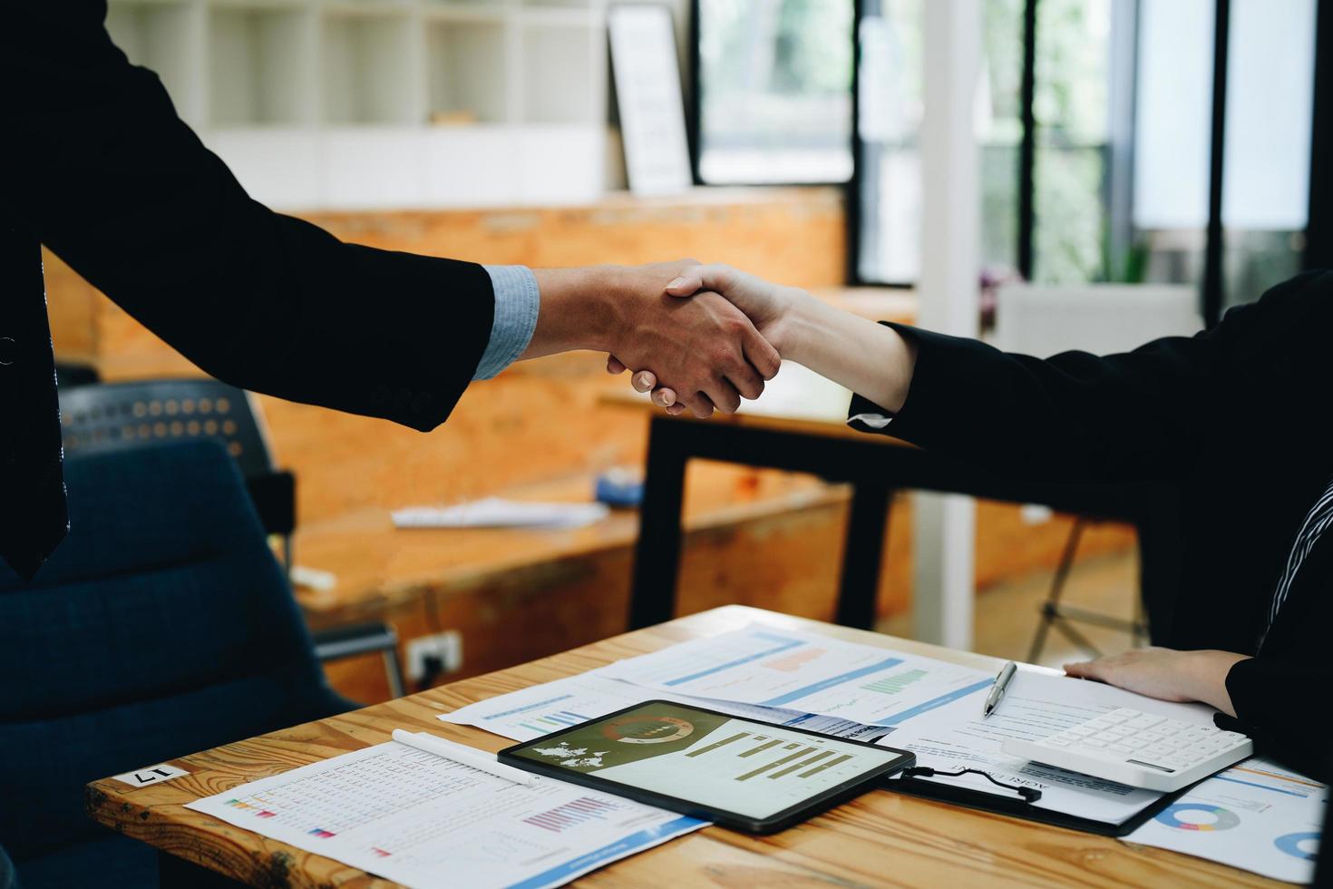 dois empresários apertam as mãos depois de aceitarem uma proposta de negócios juntos, um aperto de mão é uma homenagem universal, muitas vezes usada em saudação ou parabéns. foto