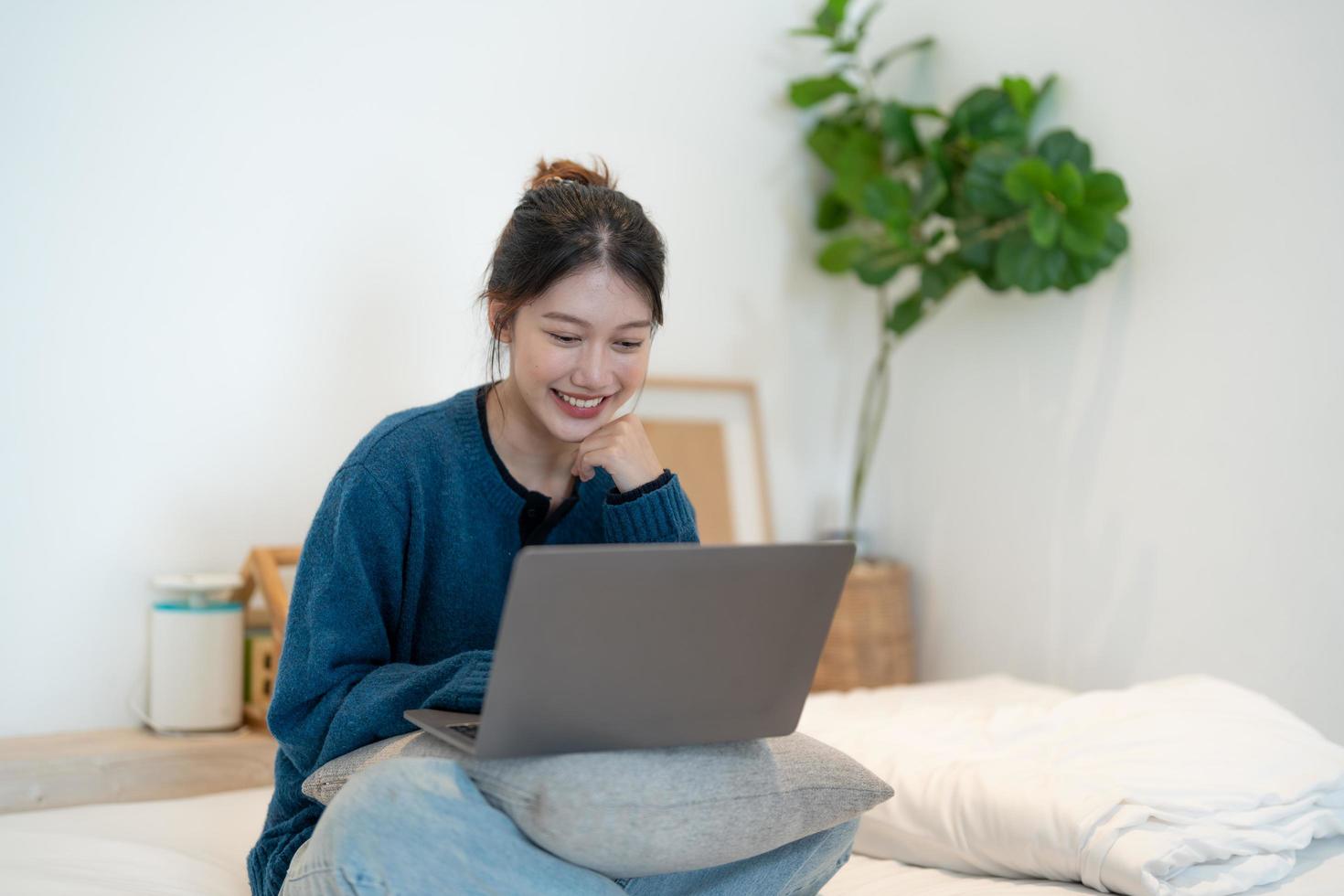 garota trabalhando no laptop em casa ou estudante estudando em casa ou freelancer. ou ela está assistindo a um vídeo ou usando a internet foto