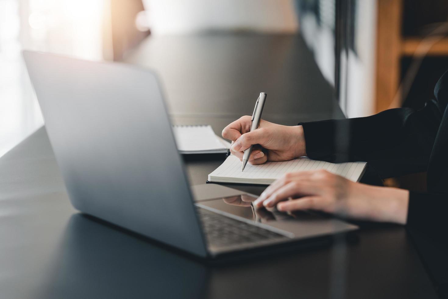 foto recortada de mulher escrevendo fazendo lista tomando notas no bloco de notas trabalhando ou aprendendo no laptop dentro de casa - curso educacional ou treinamento, seminário, conceito on-line de educação