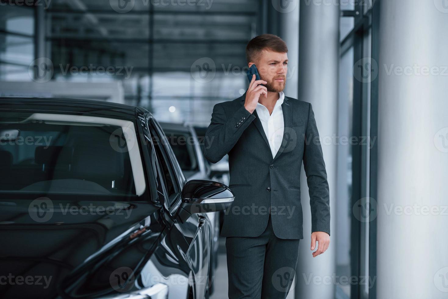 novas ofertas estão chegando. empresário barbudo elegante moderno no salão de automóveis foto