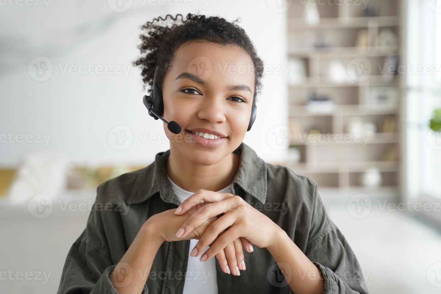 assistente virtual. jovem afro no fone de ouvido é operadora do serviço de suporte ao cliente em casa. foto