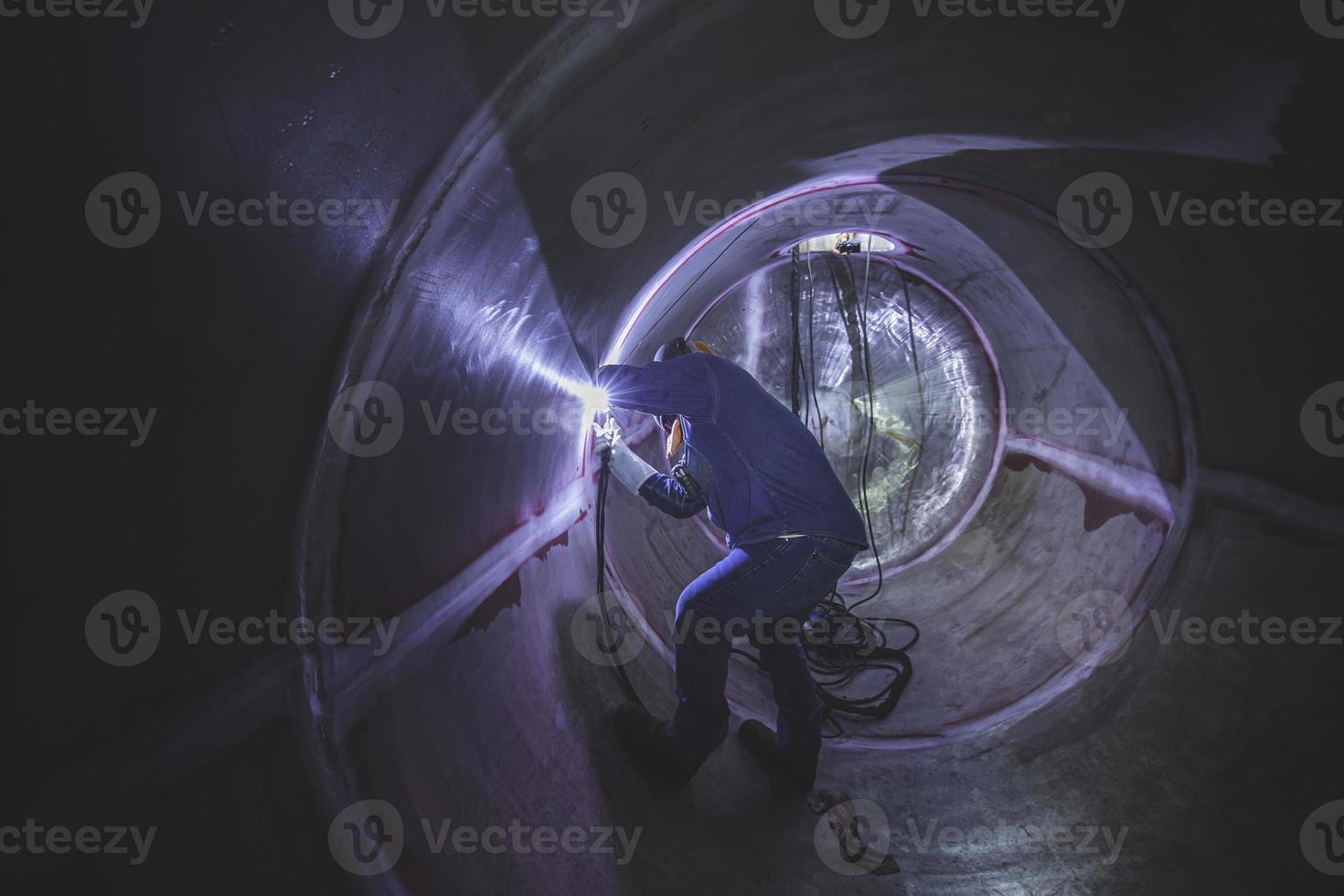 trabalhador de argônio de soldagem macho reparado metal está soldando faíscas tanque de construção industrial inoxidável foto