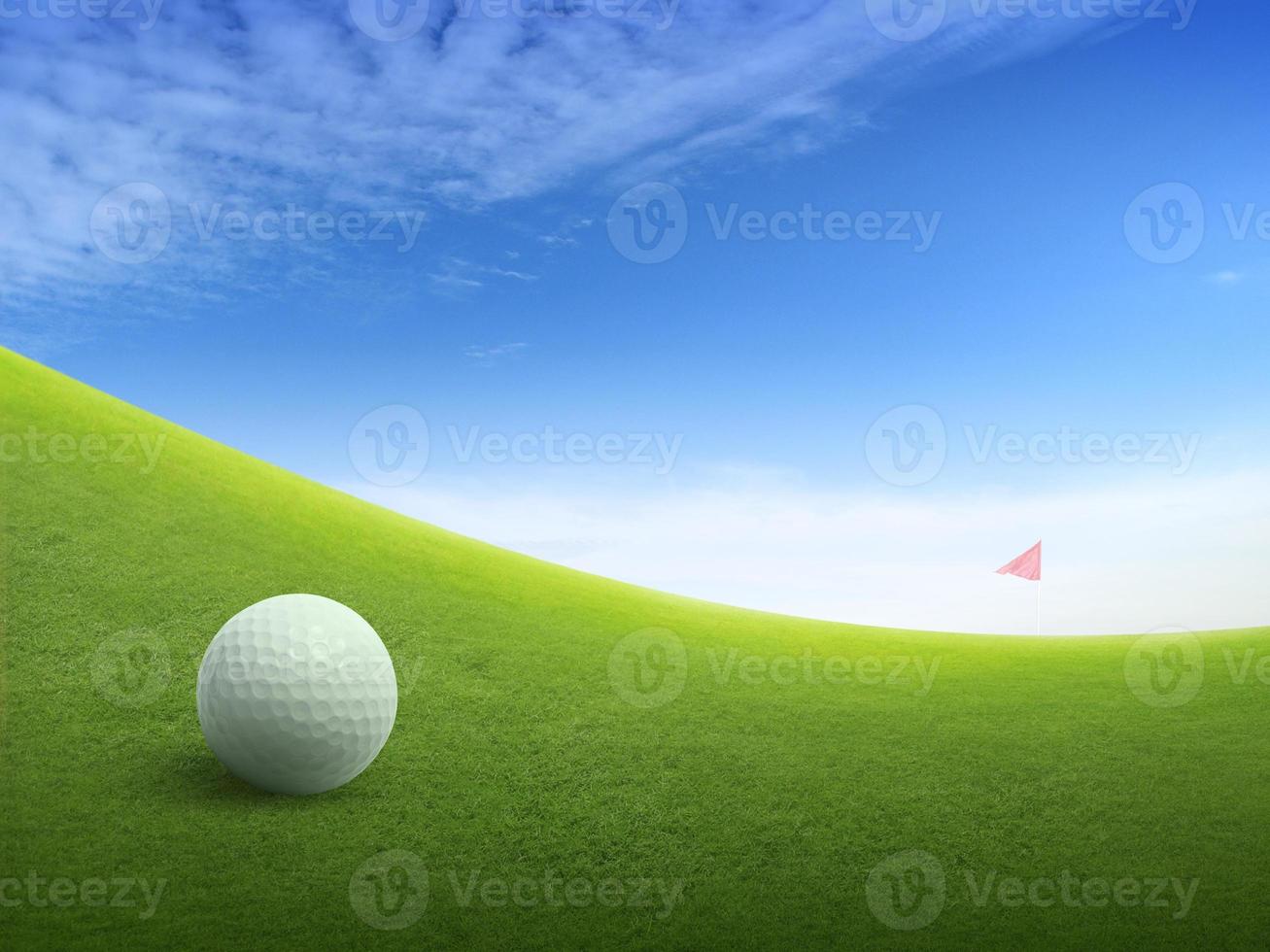 fechar a bola de golfe no campo de grama verde e bandeira de golfe vermelha no fairway verde com lindo céu azul foto