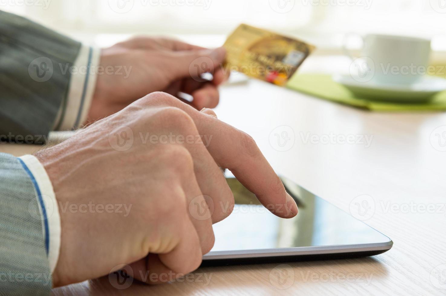 homem com cartão de crédito e tablet pc foto