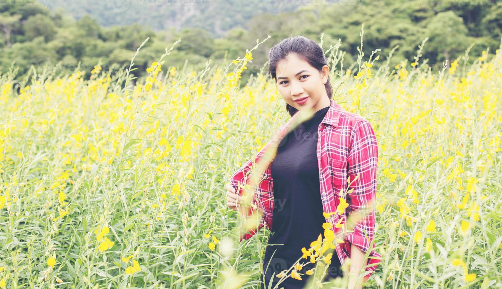 jovem e bela mulher de pé no gozo do campo de flores. foto