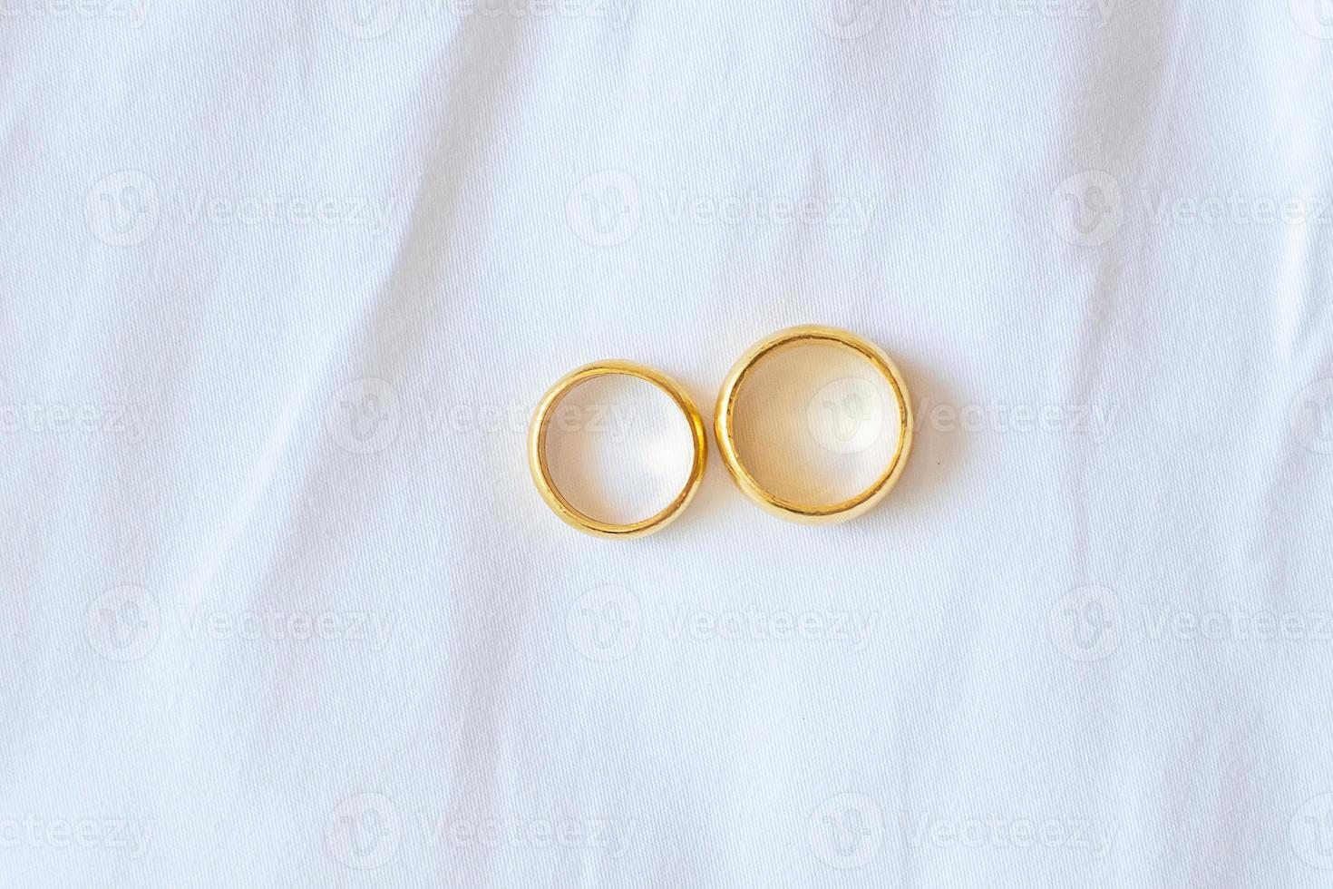 casal anel de noivado dourado sobre fundo branco. amor, juntos e feliz dia dos namorados conceito foto