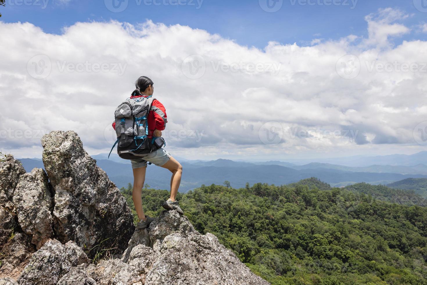 menina na montanha olhe para o belo vale na neblina no verão. paisagem com mulheres jovens desportivas, caminhadas, viagens e turismo. foto