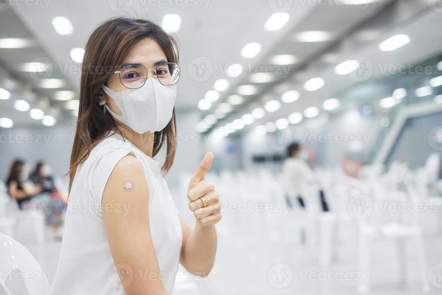 mulher feliz mostrando o polegar depois de receber a vacina. vacinação, imunização, inoculação e pandemia de coronavírus foto