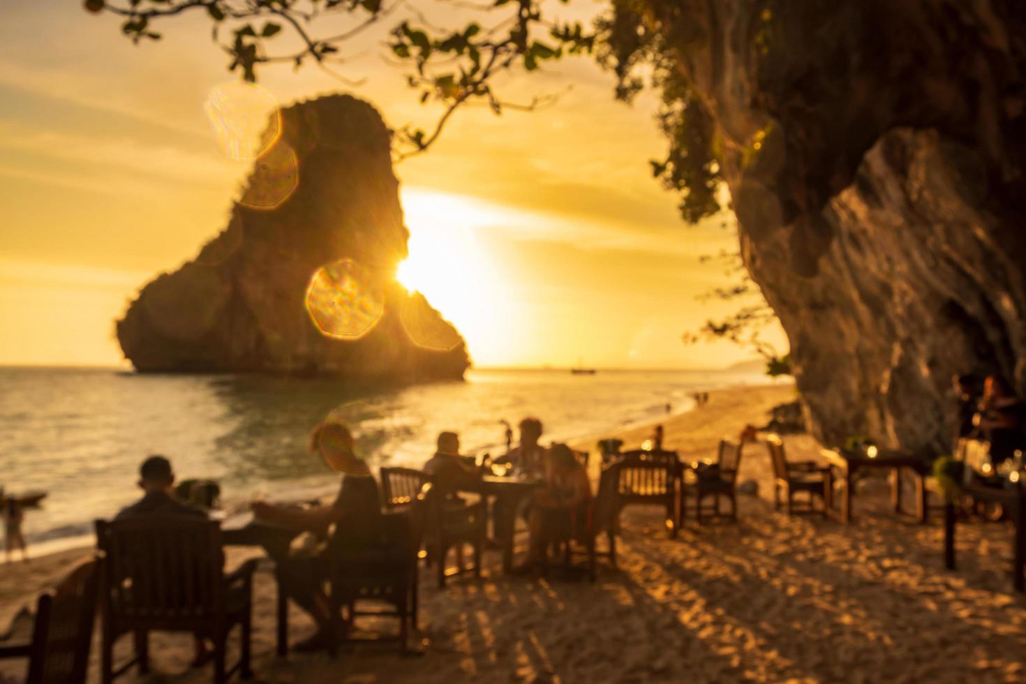 borrão da caverna do restaurante na praia de phra nang ao pôr do sol, railay, krabi, tailândia. férias, viagens, verão, desejo de viajar e conceito de férias foto