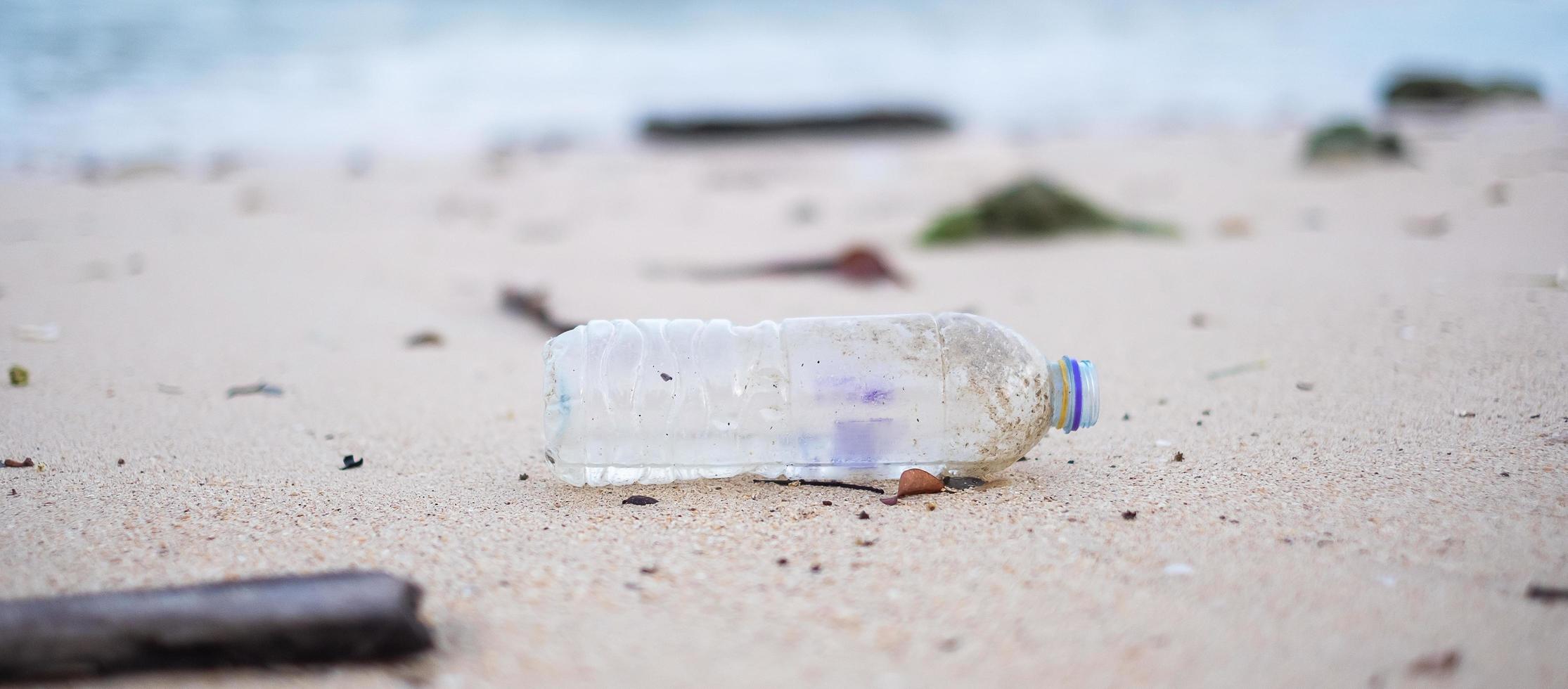 lixo de garrafa de plástico na praia. ecologia, meio ambiente, poluição e conceito de problema ecológico foto