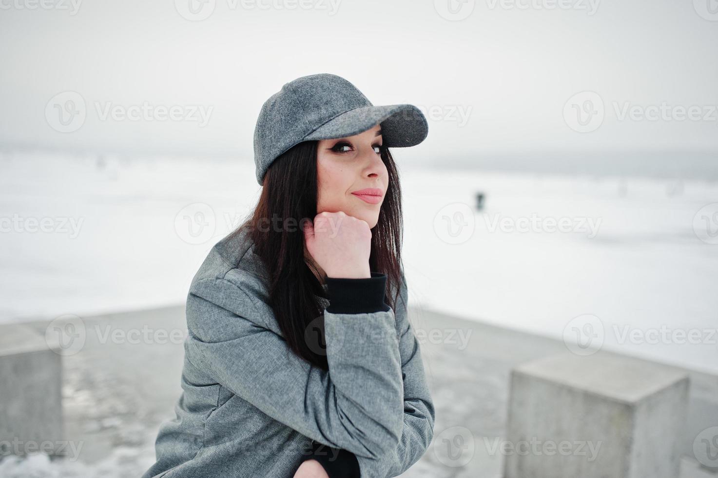 menina morena elegante boné cinza, estilo de rua casual em dia de inverno. foto