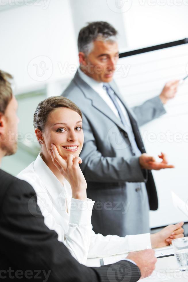 mulher sorridente, sentado em uma reunião de negócios com colegas foto