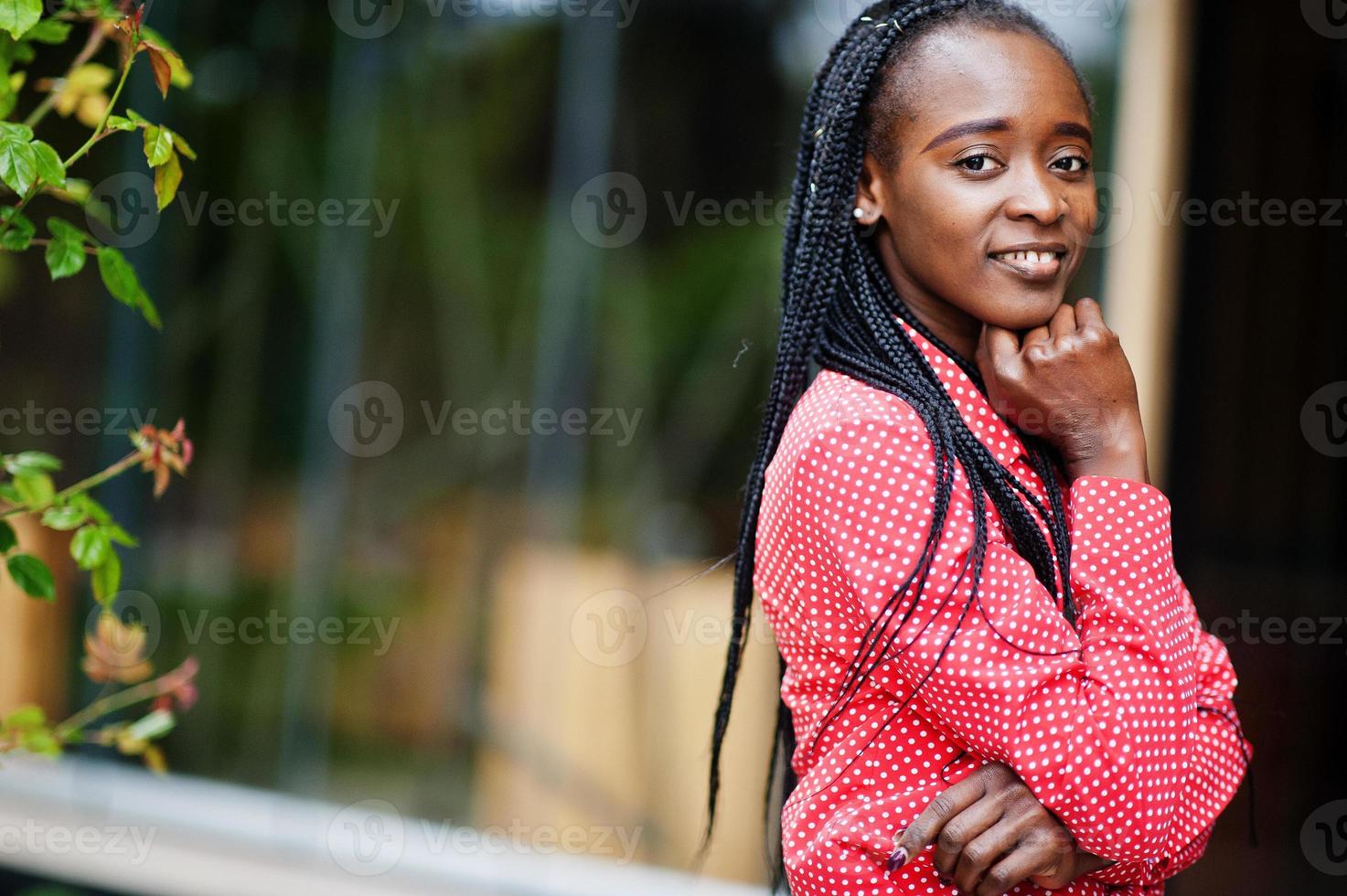 bonito tranças negócio afro-americano senhora brilhante mandão pessoa amigável desgaste escritório camisa vermelha. foto