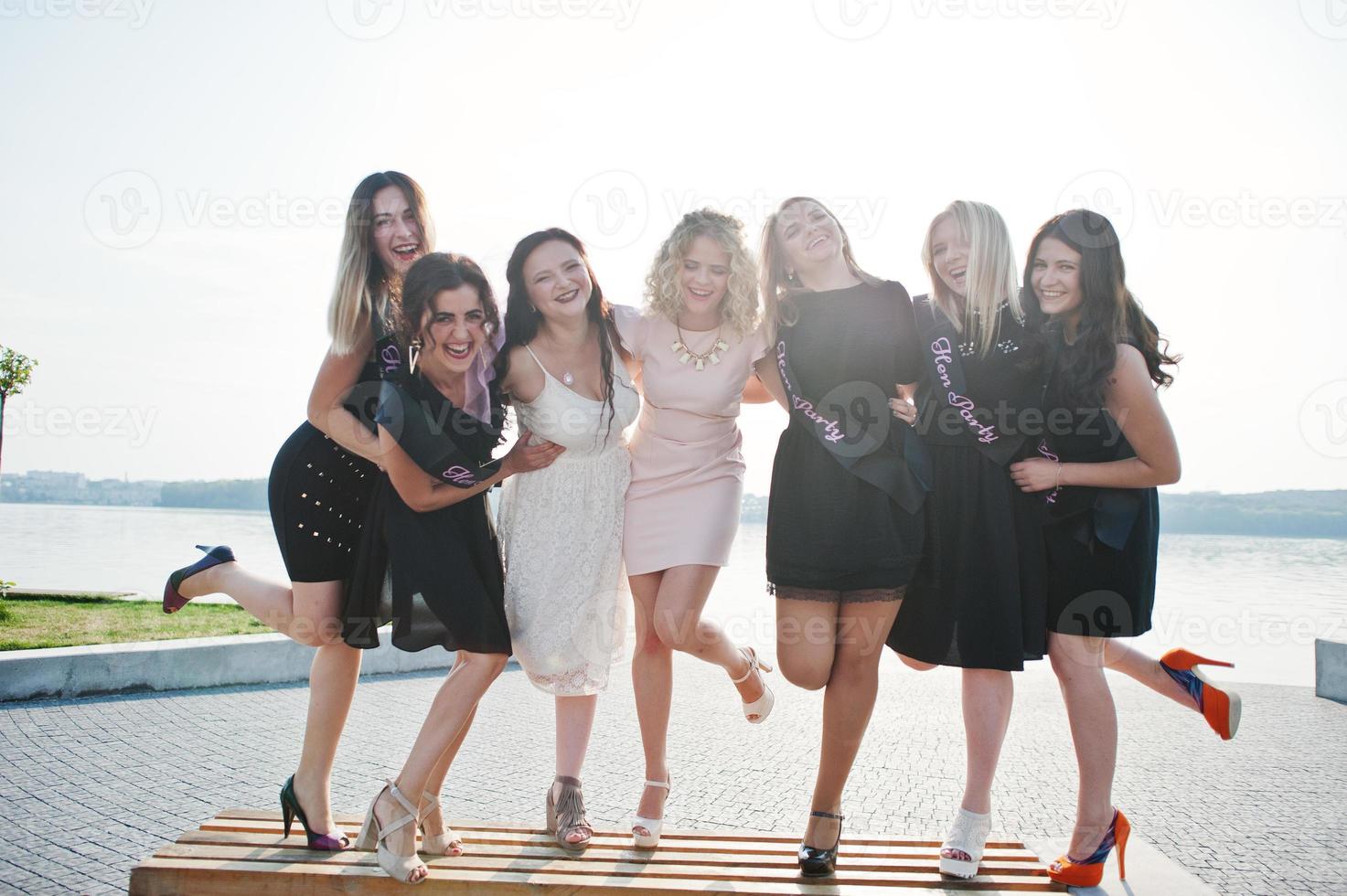 grupo de 7 meninas vestem preto e 2 noivas na despedida de solteira. foto
