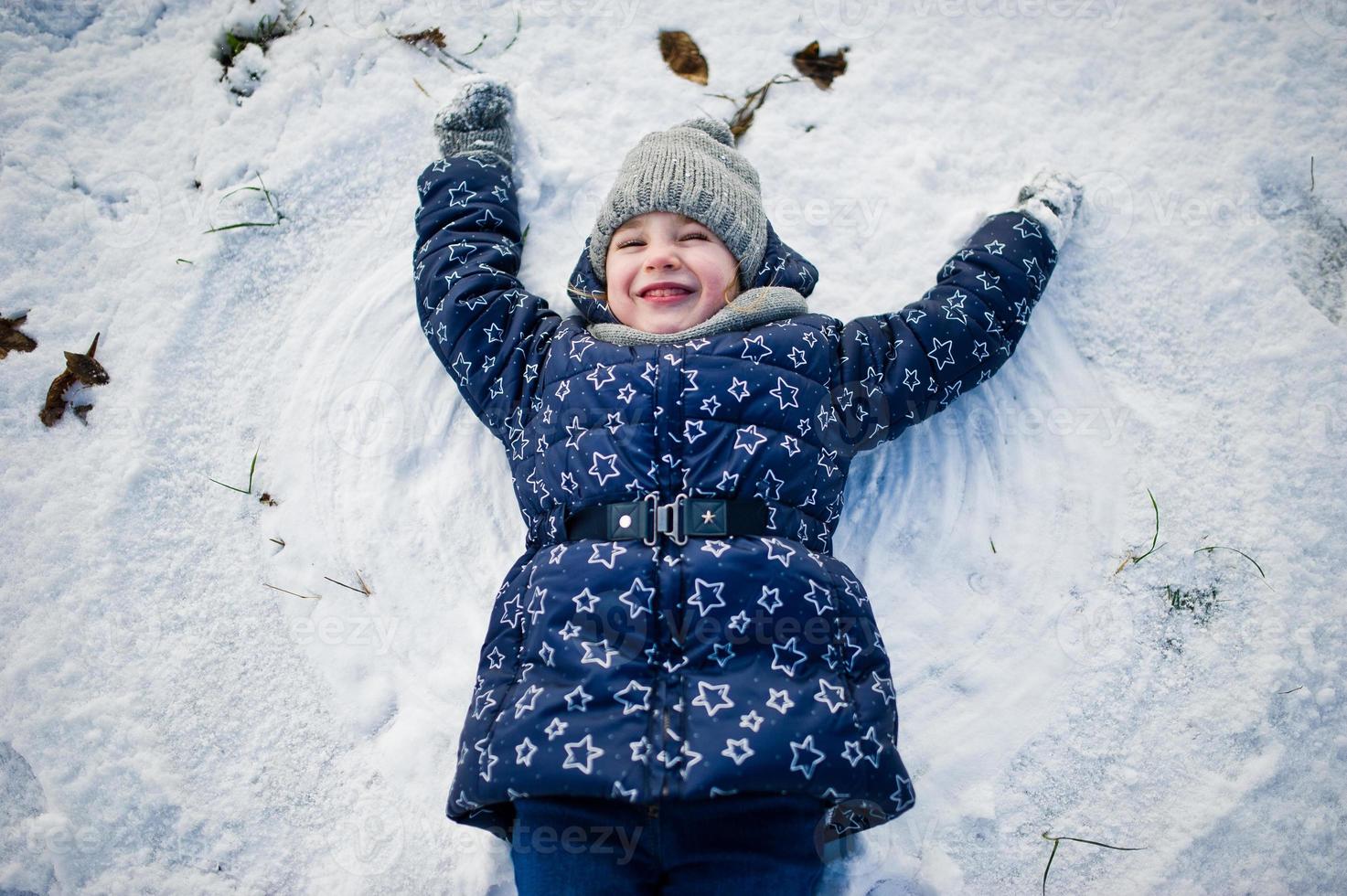 menina bonitinha se divertindo ao ar livre em dia de inverno. foto