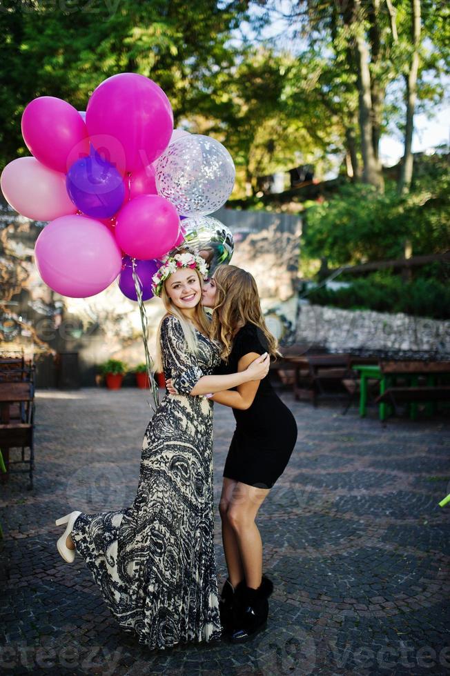 duas garotas usam preto com balões na festa de despedida. foto