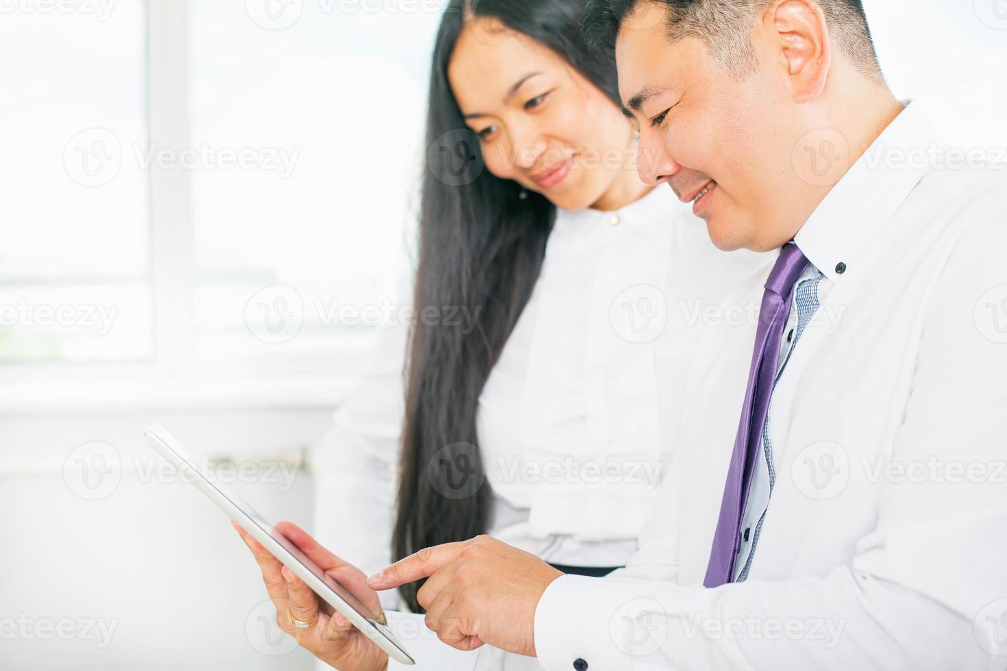 pessoas de negócios, vestidas de branco, usando o tablet pc no escritório foto
