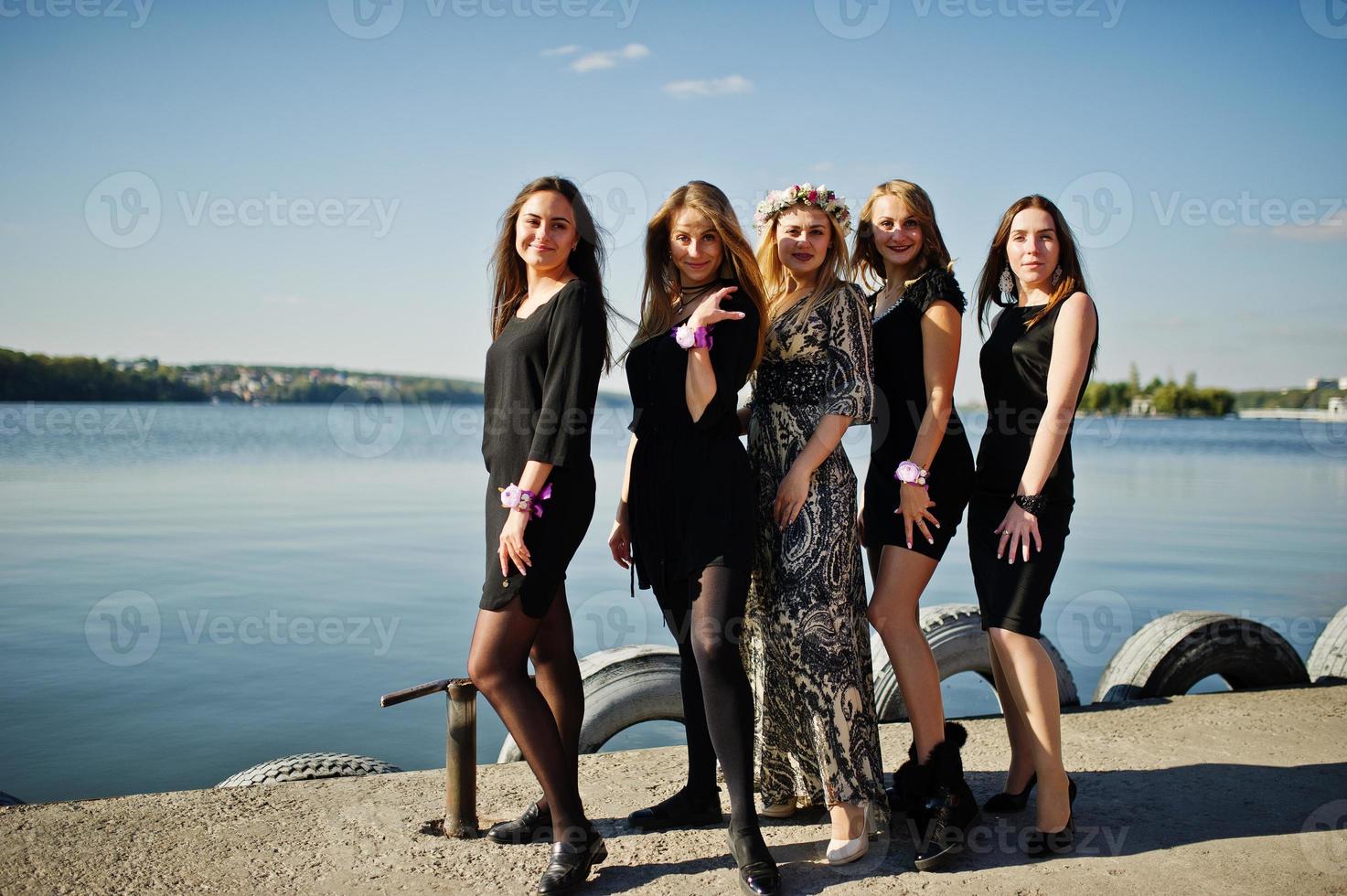 cinco garotas usam preto se divertindo contra o lago na festa de despedida. foto