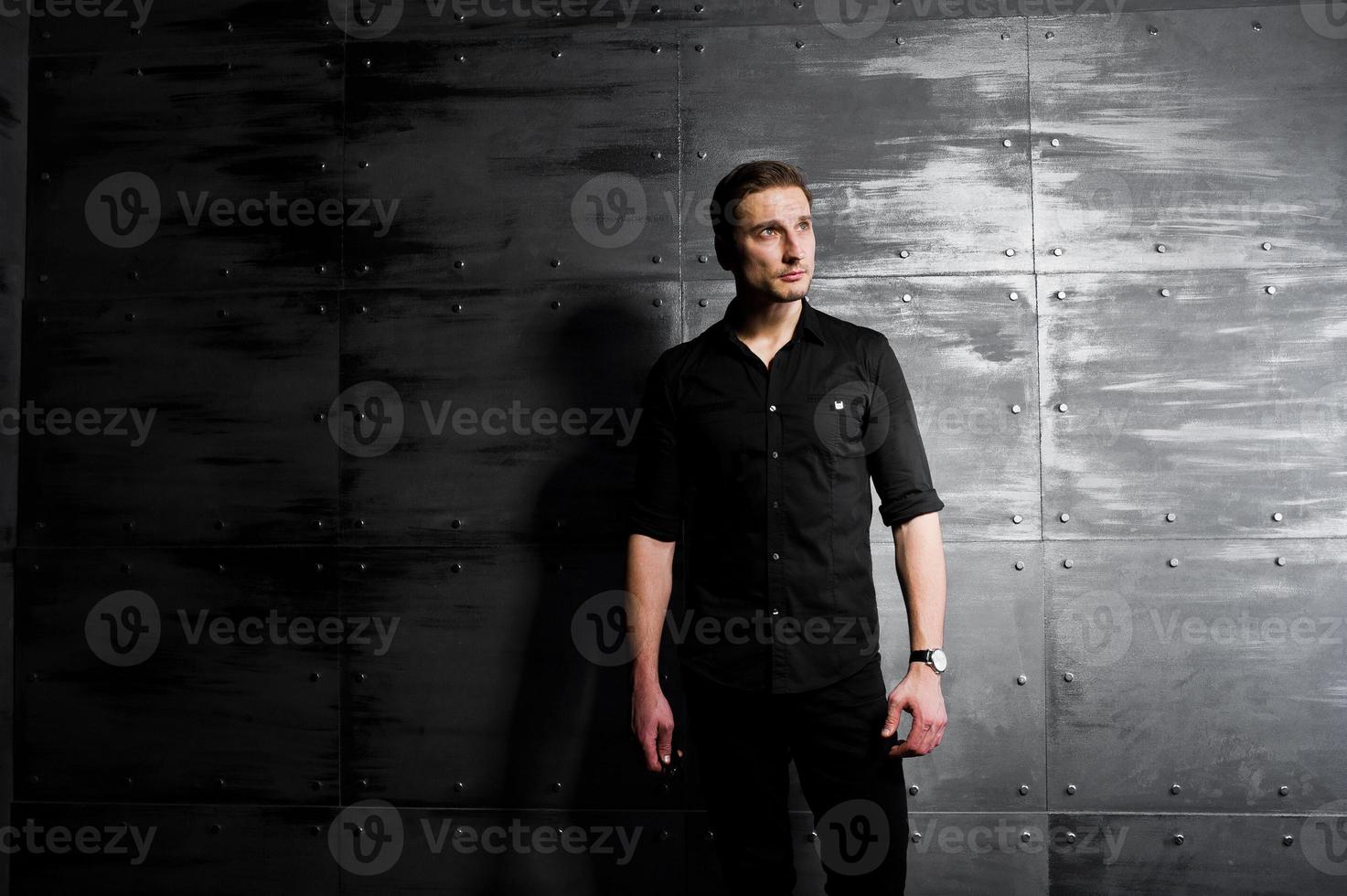 retrato de estúdio de homem elegante usar camisa preta contra a parede de aço. foto
