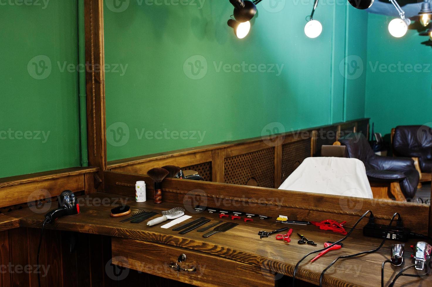 equipamento de barbeiro na superfície de trabalho pelo espelho na barbearia. foto