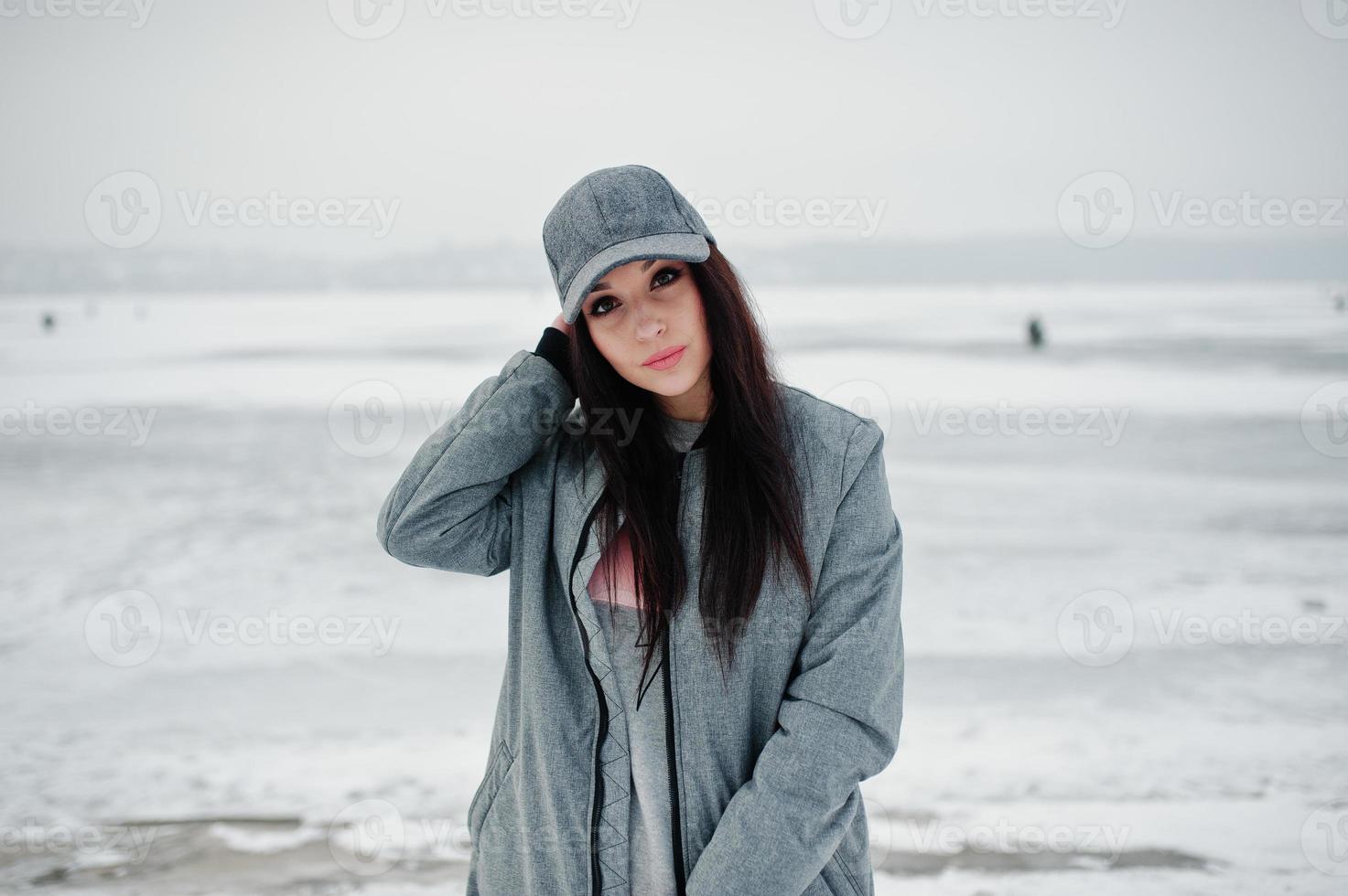 menina morena elegante boné cinza, estilo de rua casual em dia de inverno. foto