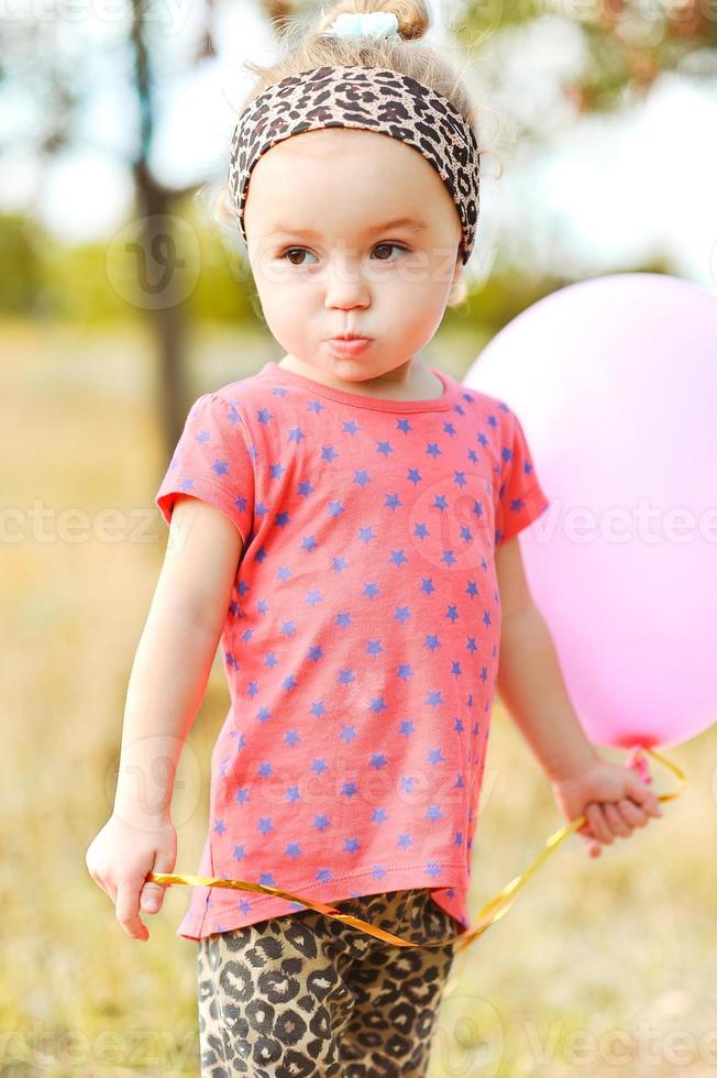 doce menina com balão ao ar livre foto