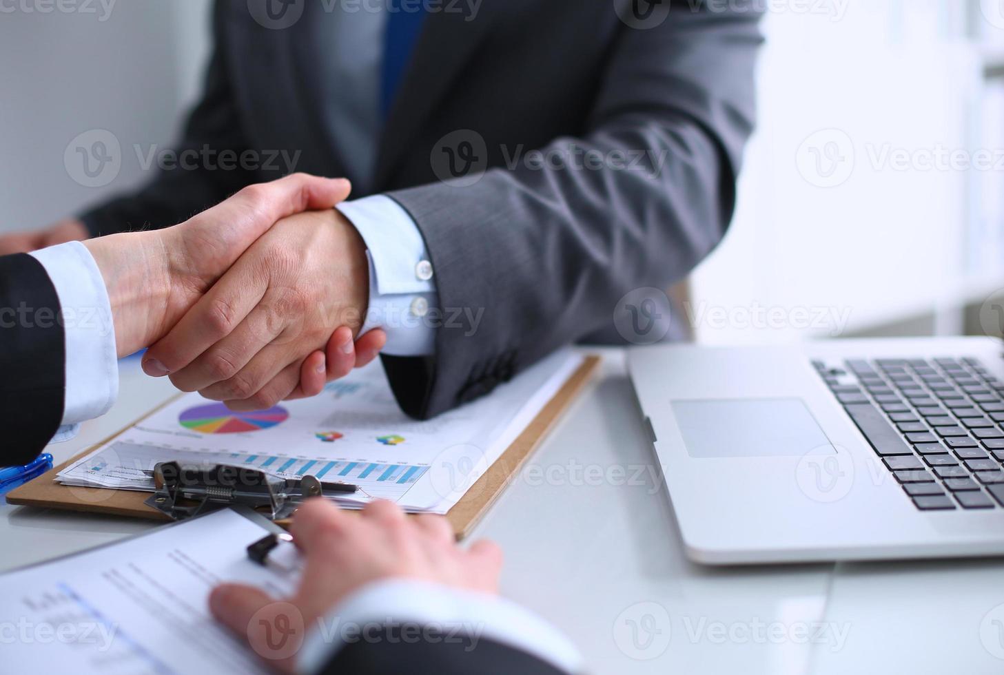 Empresários apertando as mãos, terminando uma reunião foto