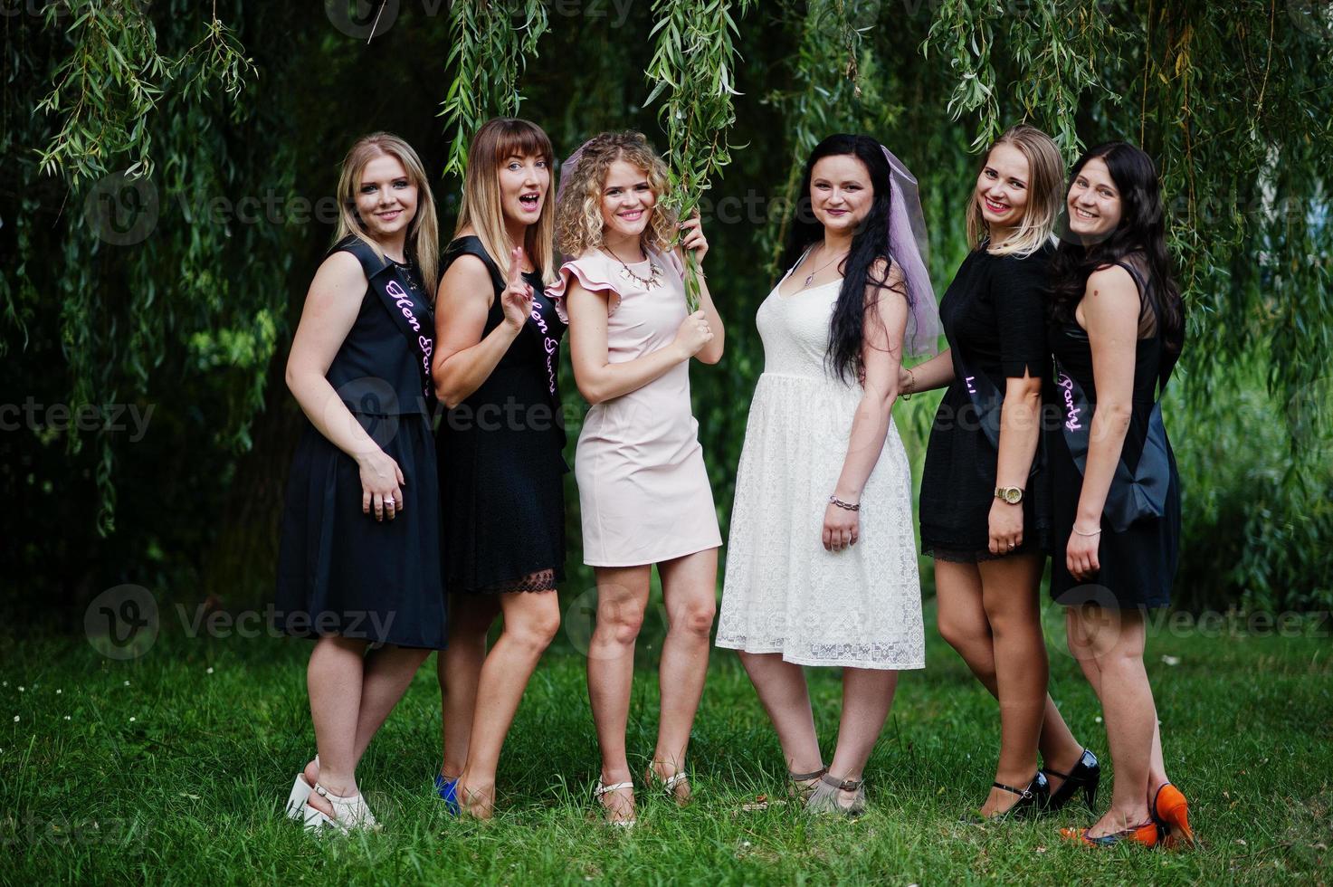 grupo de 6 meninas vestem preto e 2 noivas na despedida de solteira. foto