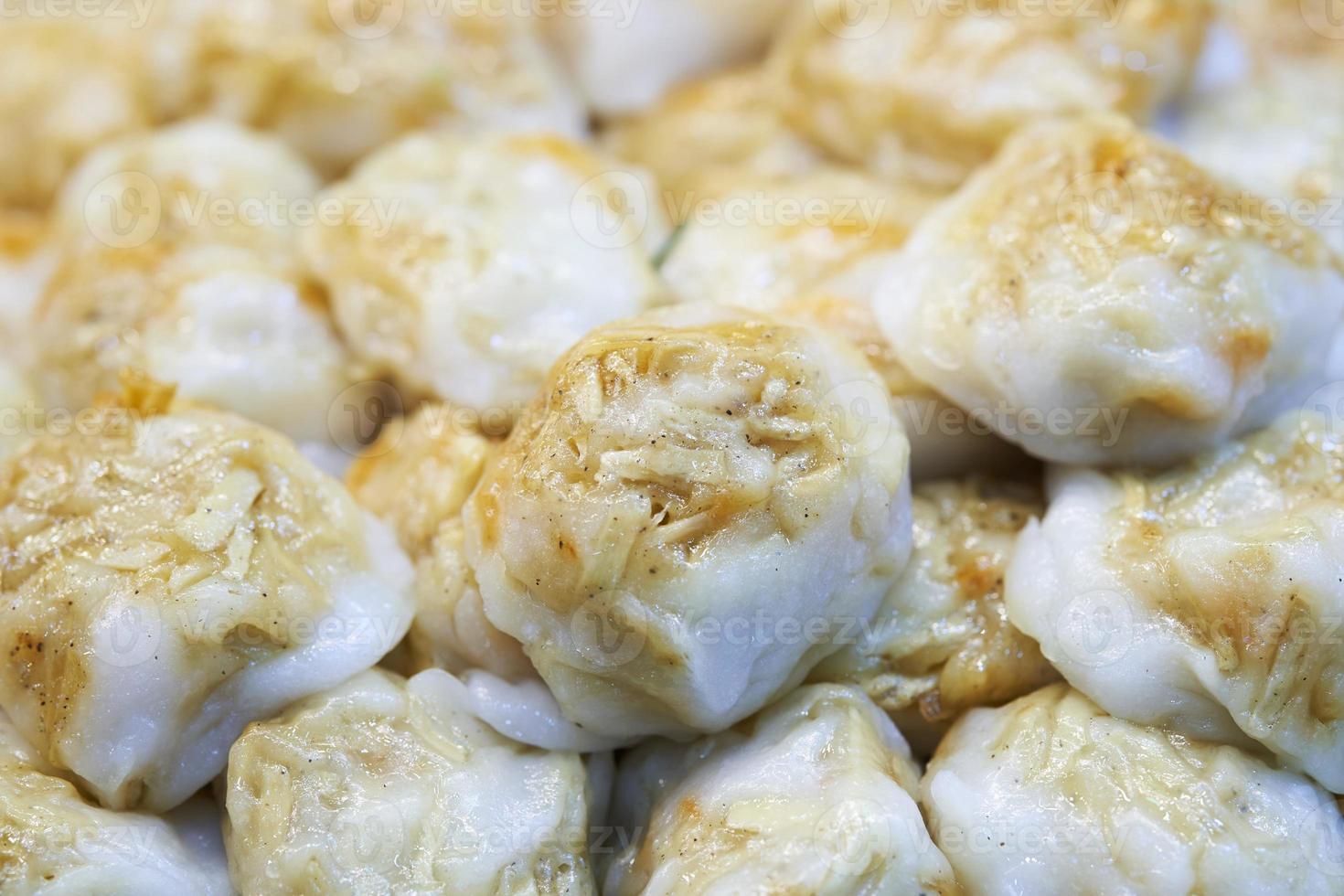 close-up de bolinho cozido no vapor recheado com cebolinha de alho, taro, inhame e bambu mercado de comida de rua tailandesa foto