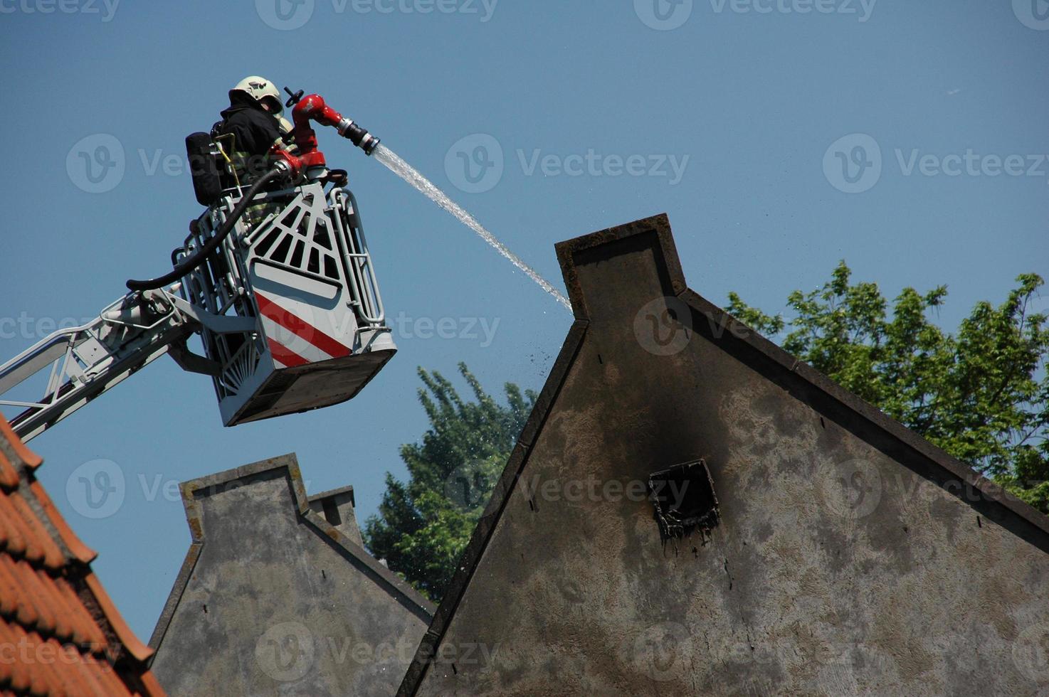 bombeiro que amortece a casa queimada foto