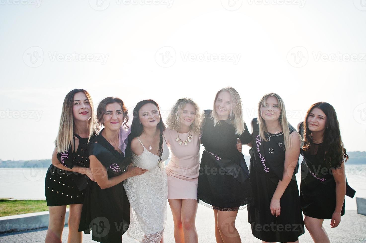 grupo de 7 meninas vestem preto e 2 noivas na despedida de solteira. foto