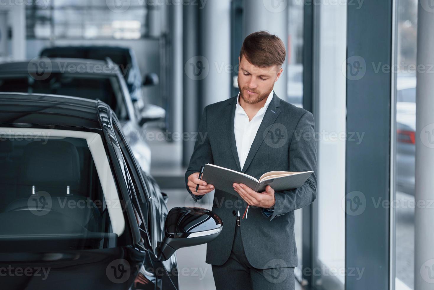 empresário barbudo elegante moderno no salão de automóveis foto