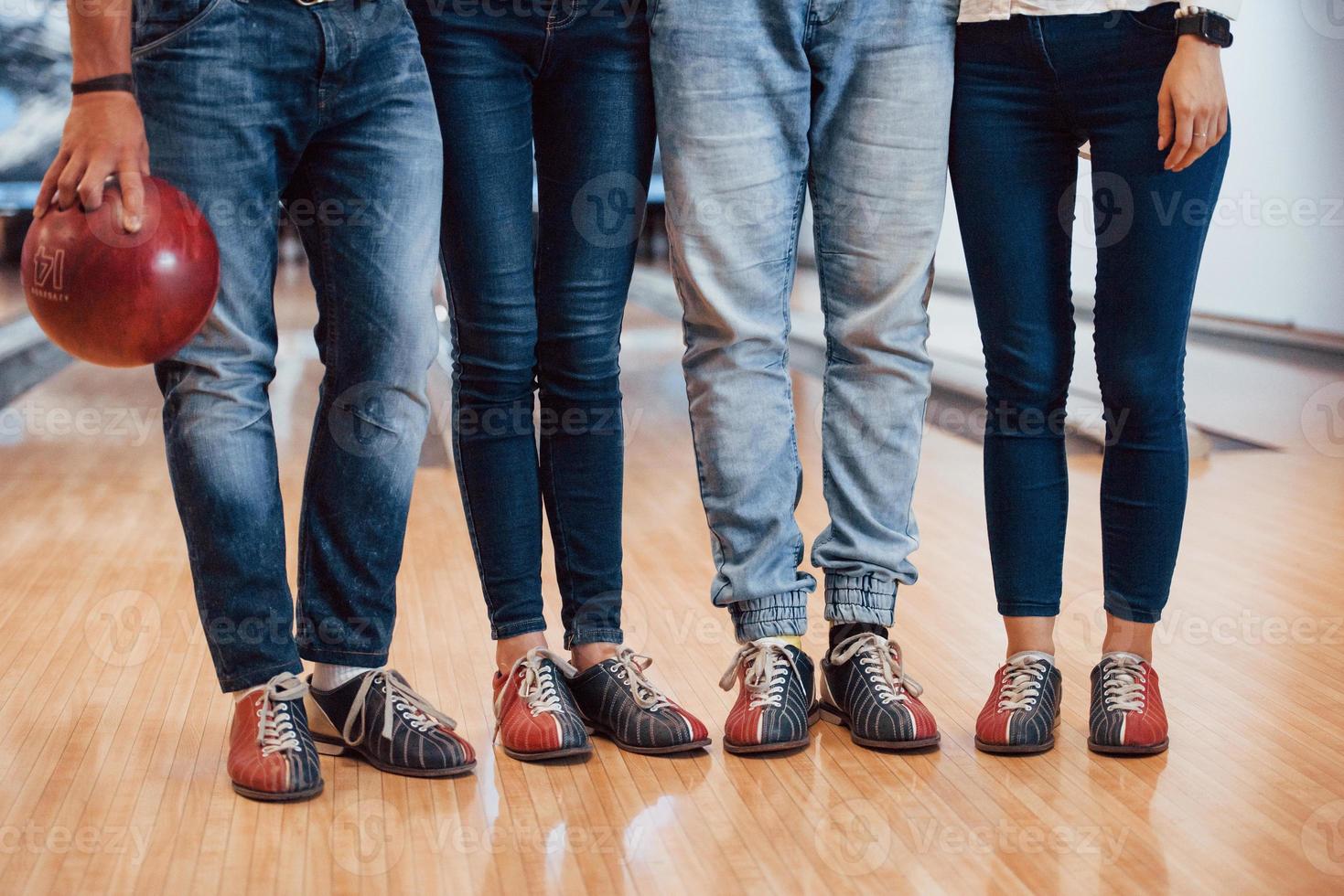 em sapatos especiais. visão recortada de pessoas no clube de boliche prontas para se divertir foto