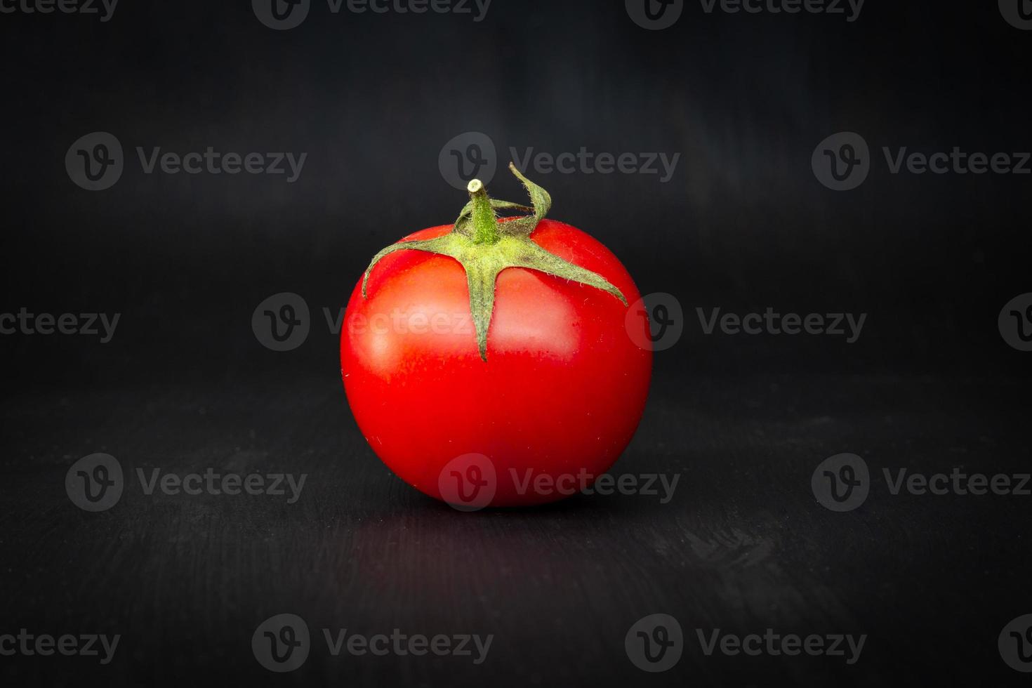 tomate cereja vermelho isolado em preto foto