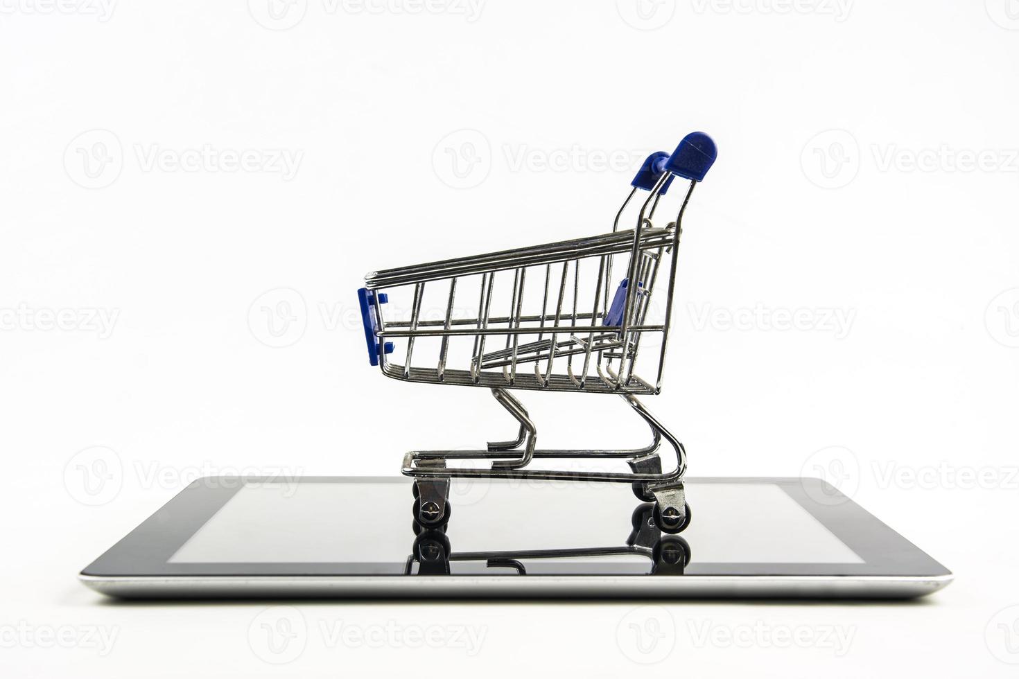 carrinho de compras com tablet em fundo branco, significa fazer compras online foto