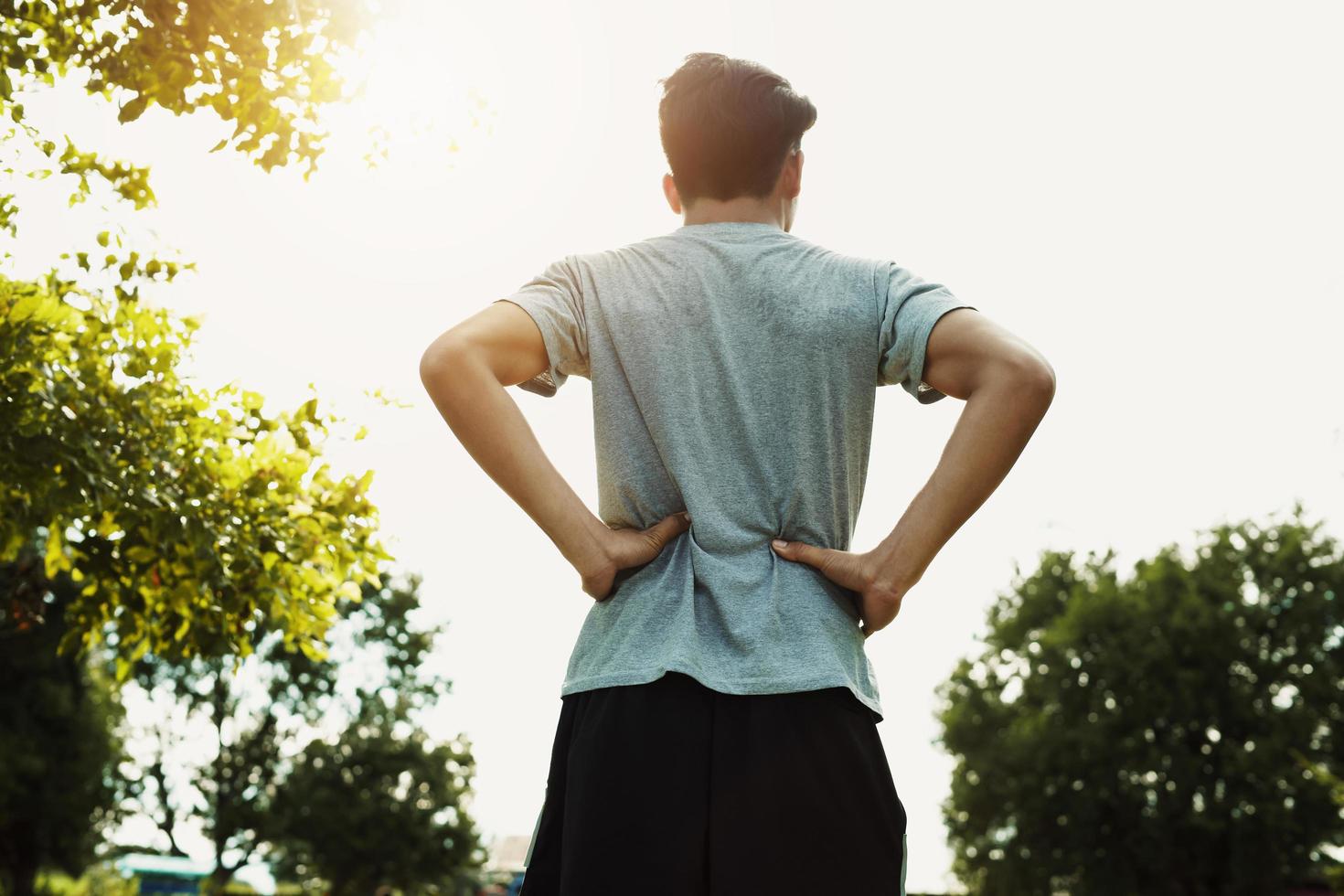 corredores dor nas costas depois de correr no parque com pôr do sol foto