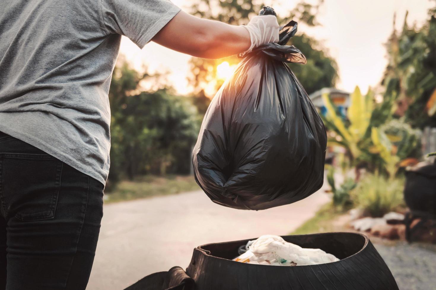 mão de mulher segurando o saco de lixo para reciclagem de limpeza foto