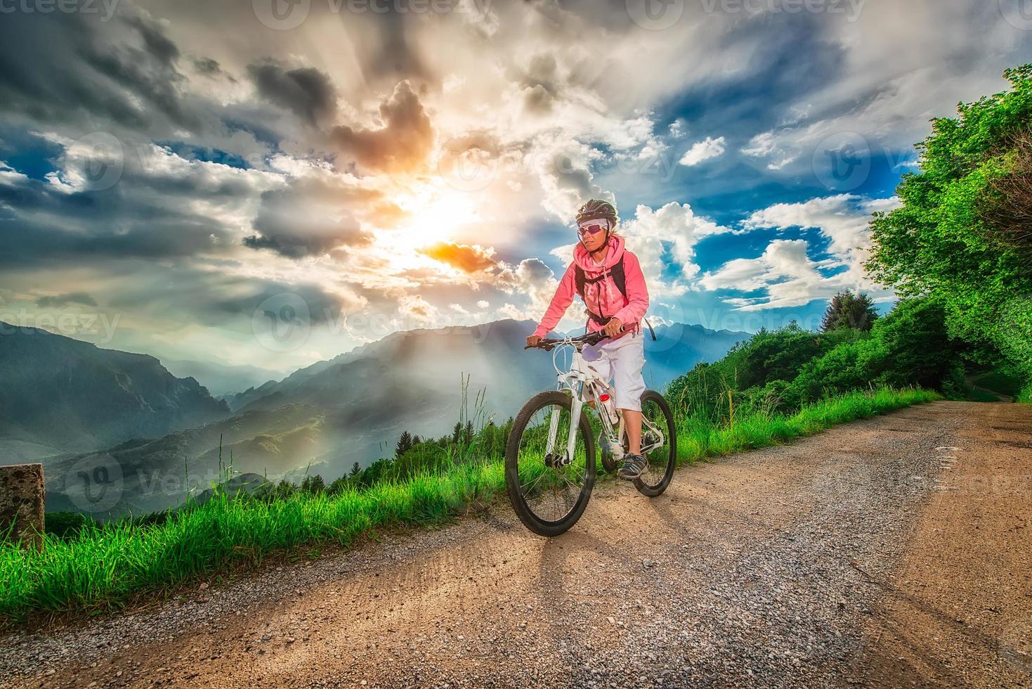 menina de bicicleta de montanha em uma estrada de montanha foto