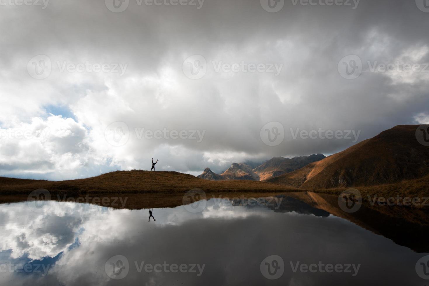 garota faz a roda perto do lago de montanha foto