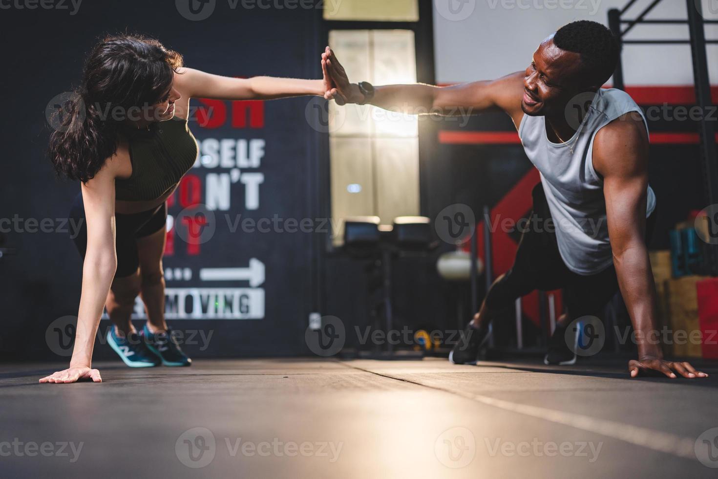 treinador de personal trainer ajudando jovem se exercitando no ginásio de esportes, treino de exercícios em fitness, corpo saudável ativo no estilo de vida esportivo, musculação de garota feliz com roupas esportivas foto