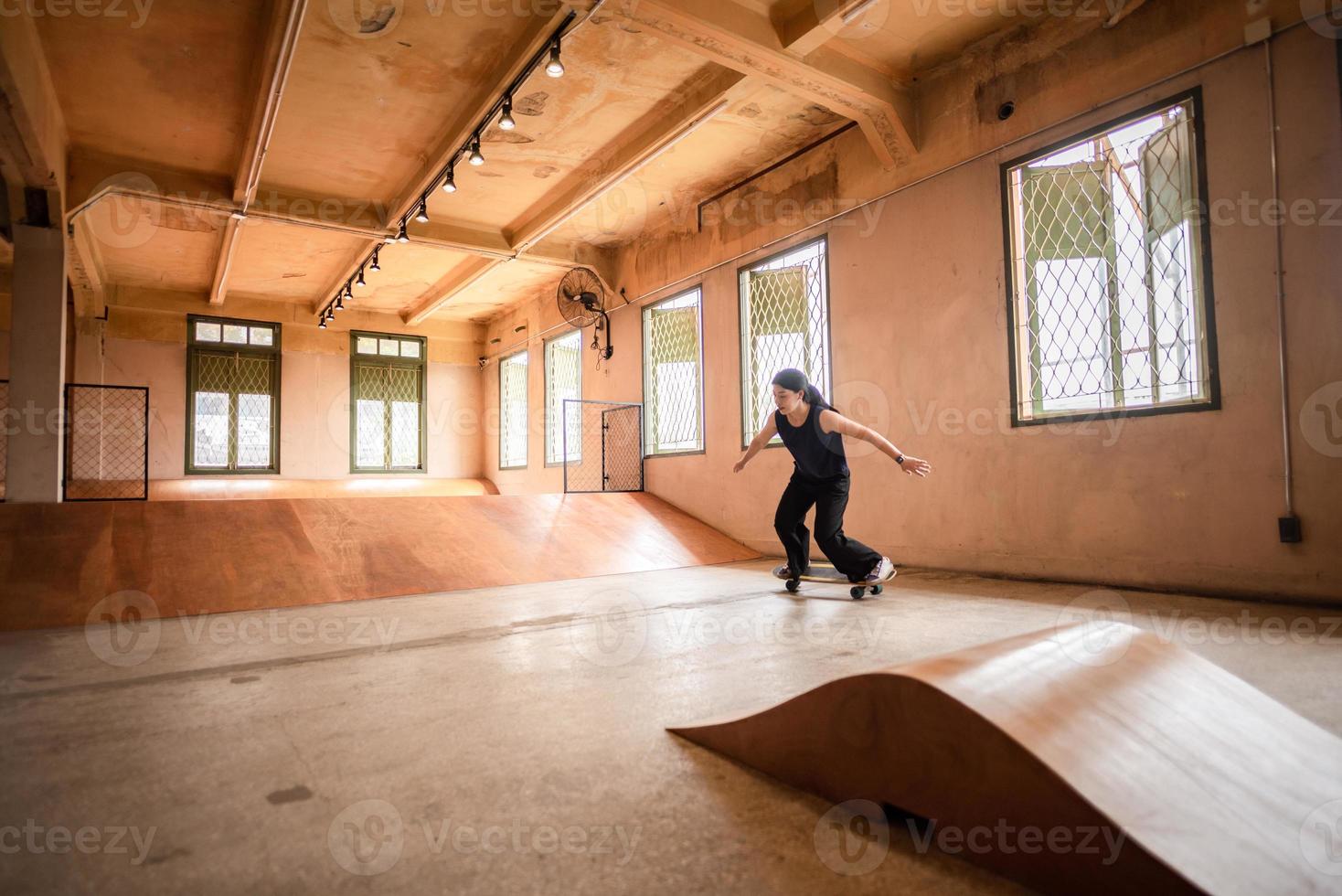 pessoa de mulher skatista jogando skate no ginásio de esportes, jovem mulher asiática é feliz e divertida com o estilo de vida de skate na cidade, moda feminina moderna adolescente hipster foto