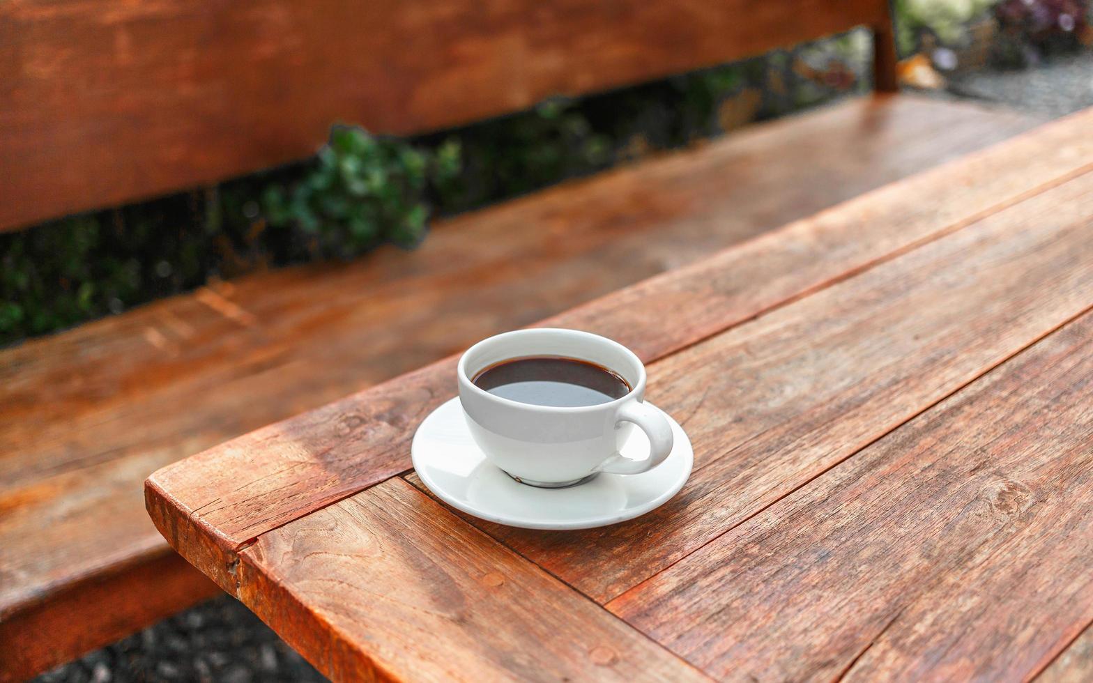 xícara de café na mesa de madeira no sol da manhã foto