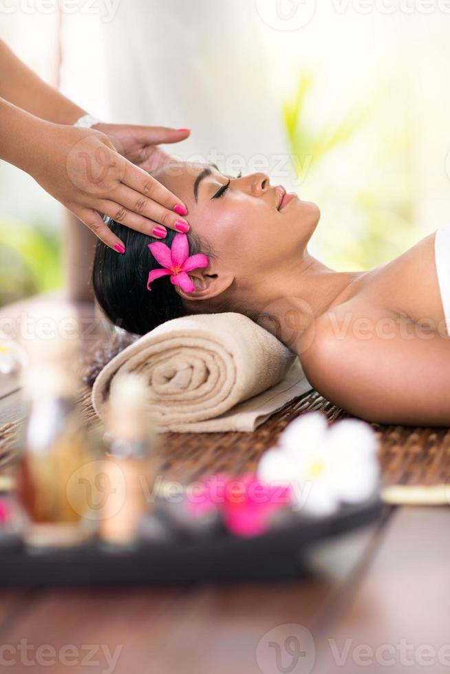 jovem mulher recebendo massagem na cabeça foto